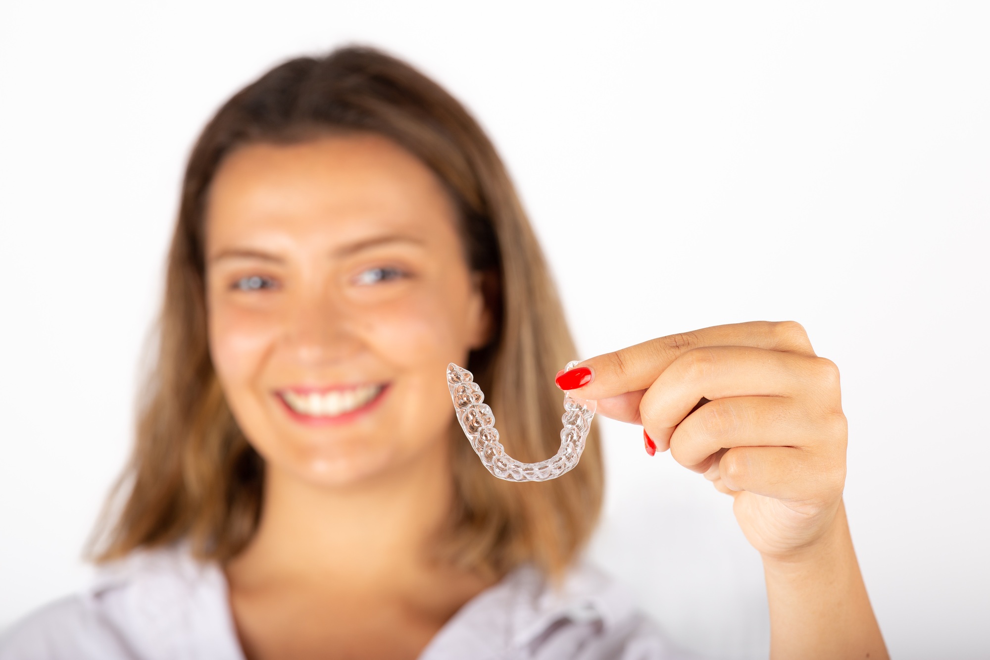 Beautiful smiling young woman with aligner.