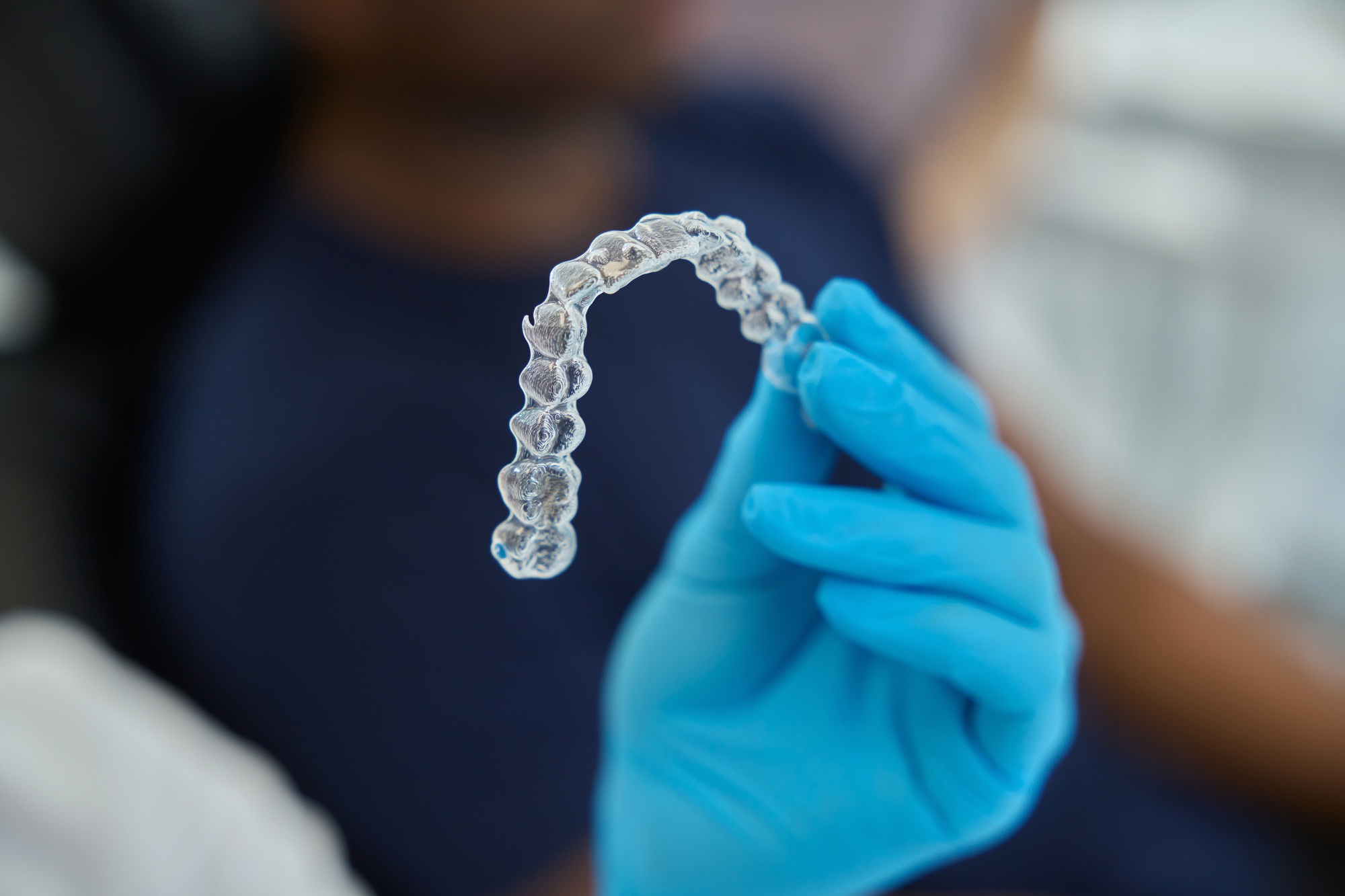 Dental aesthetic clinic worker holding clear aligners to straight teeth