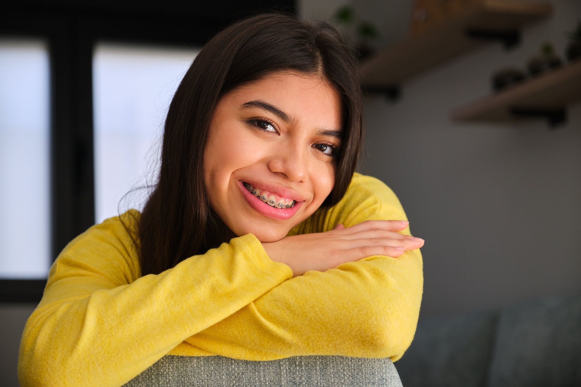 Female teenager with braces smiling and looking at camera.