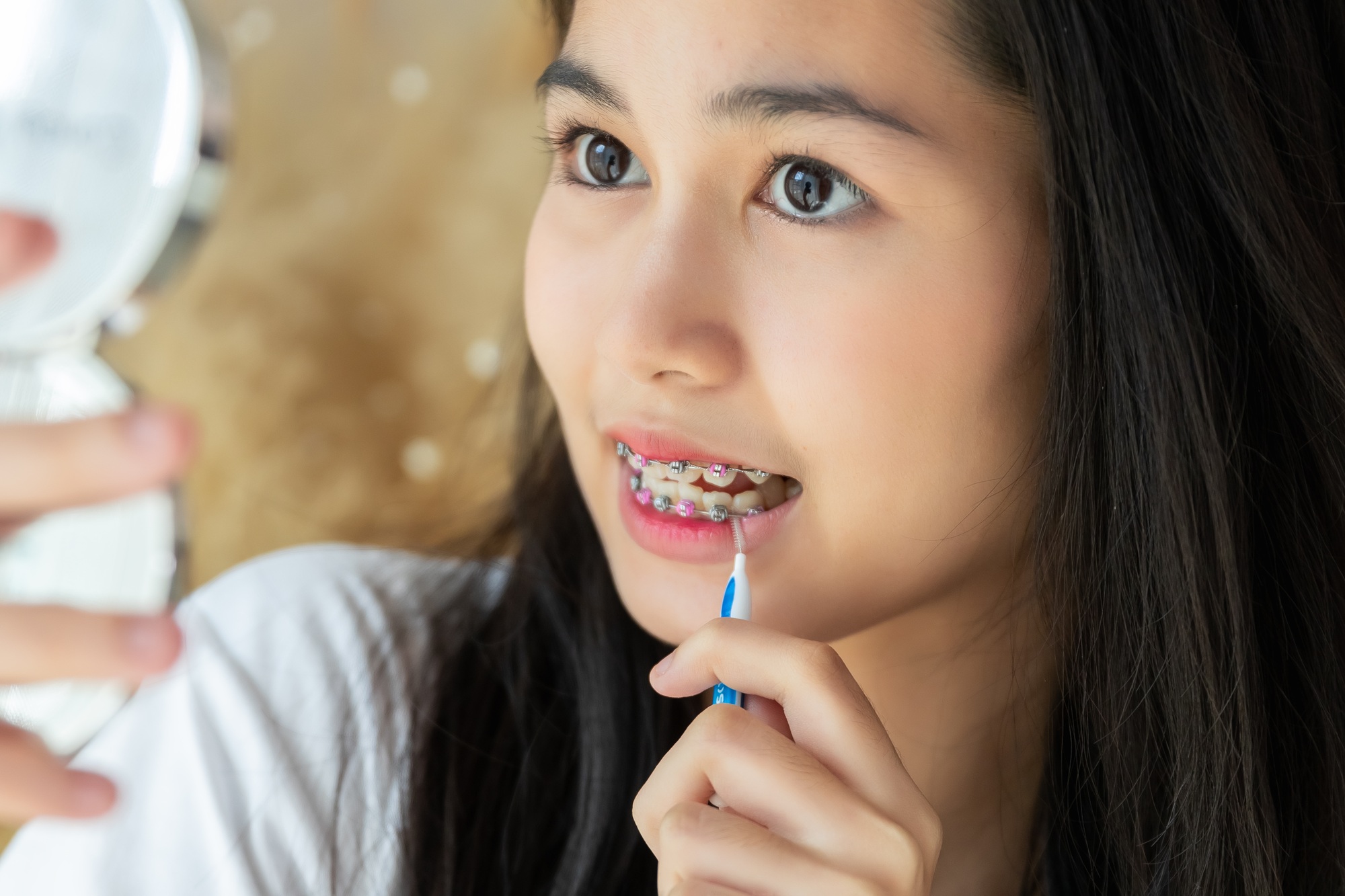 Girl using brush cleaning braces. treatment health and cleaning teeth and mouth.