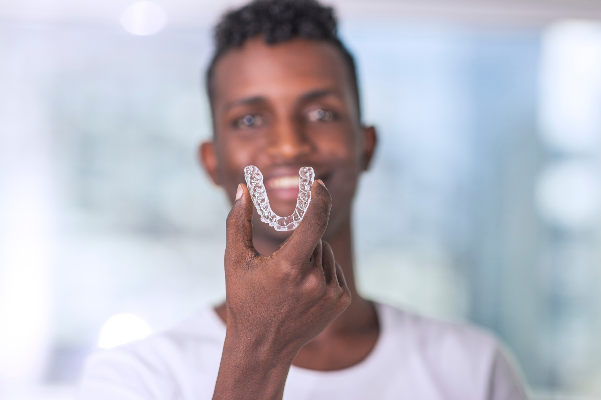 Handsome African Young Man Is Holding An Invisaligner, image with copyspace
