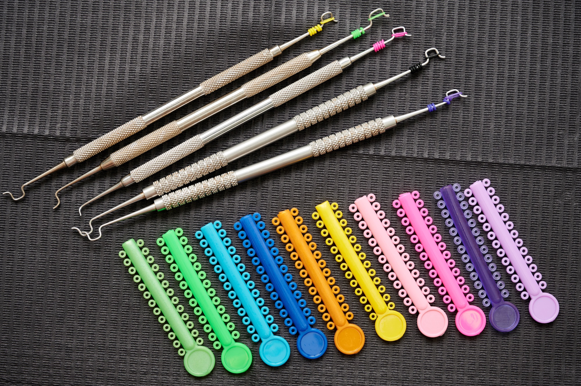 Multicolored orthodontic ligature ties and orthodontic instruments.