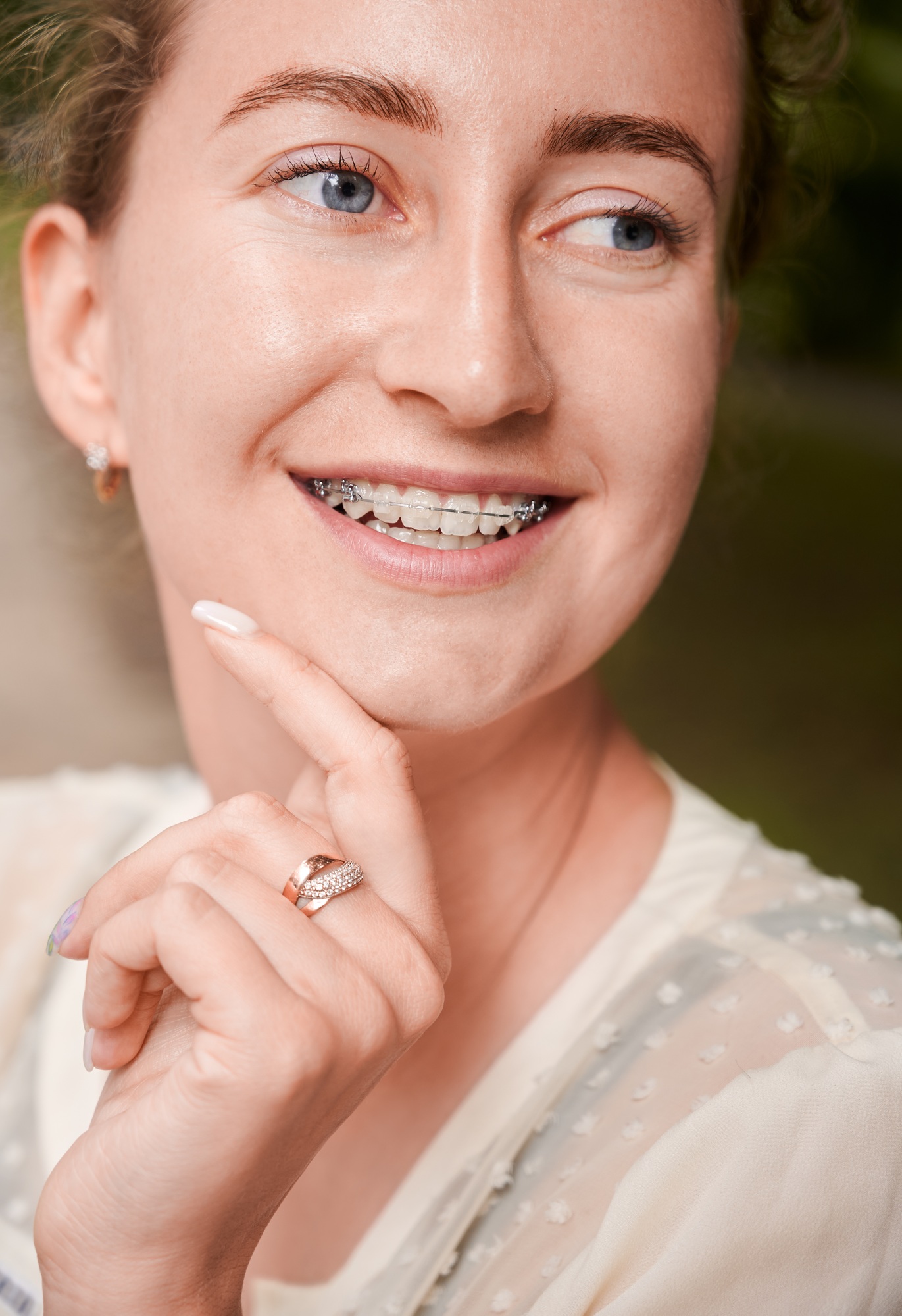 Portrait of a smiling girl outdoors, demonstrating beautiful teeth with braces